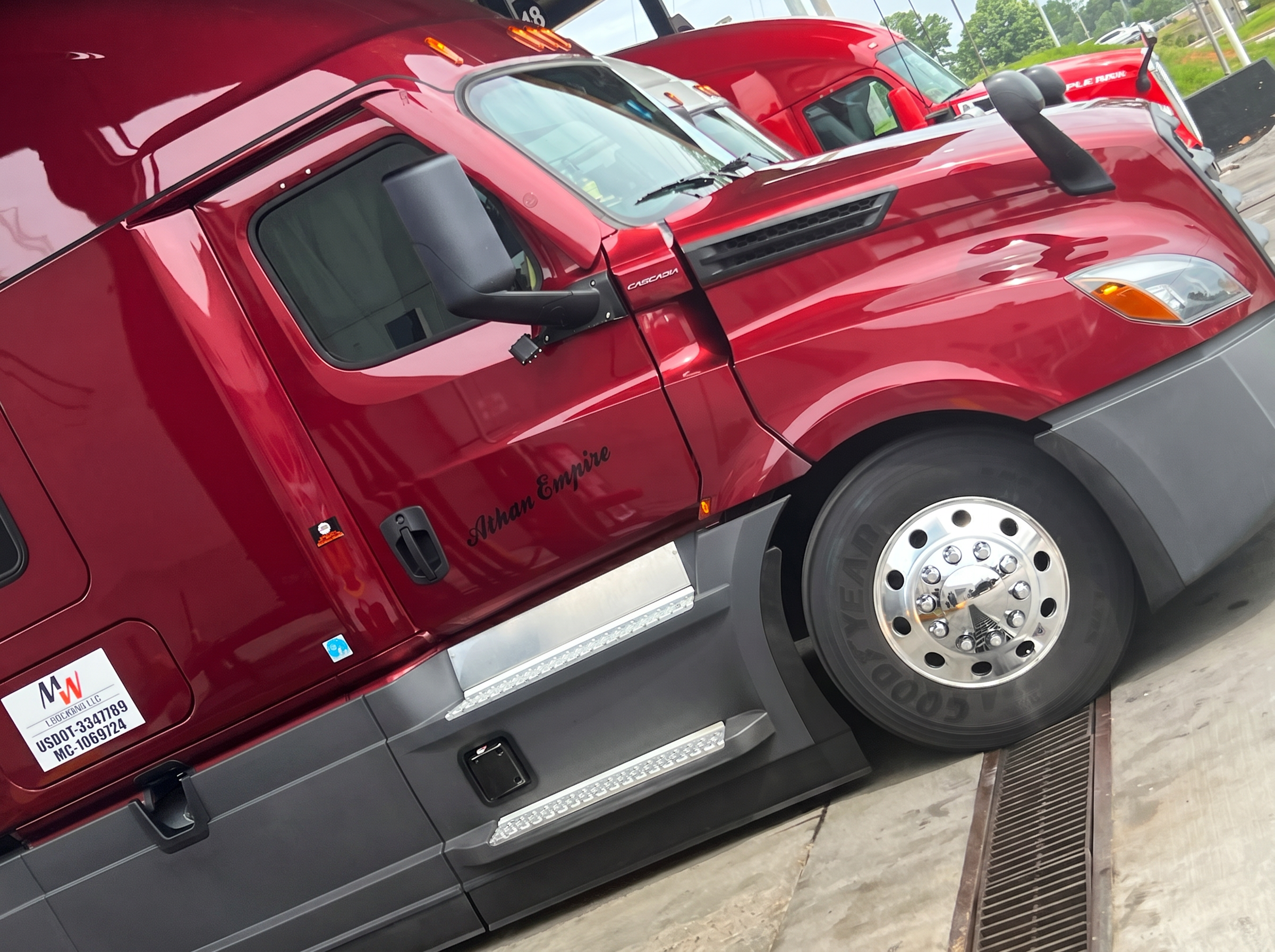 Maroon Freightliner Cascadia cab at the fuel station