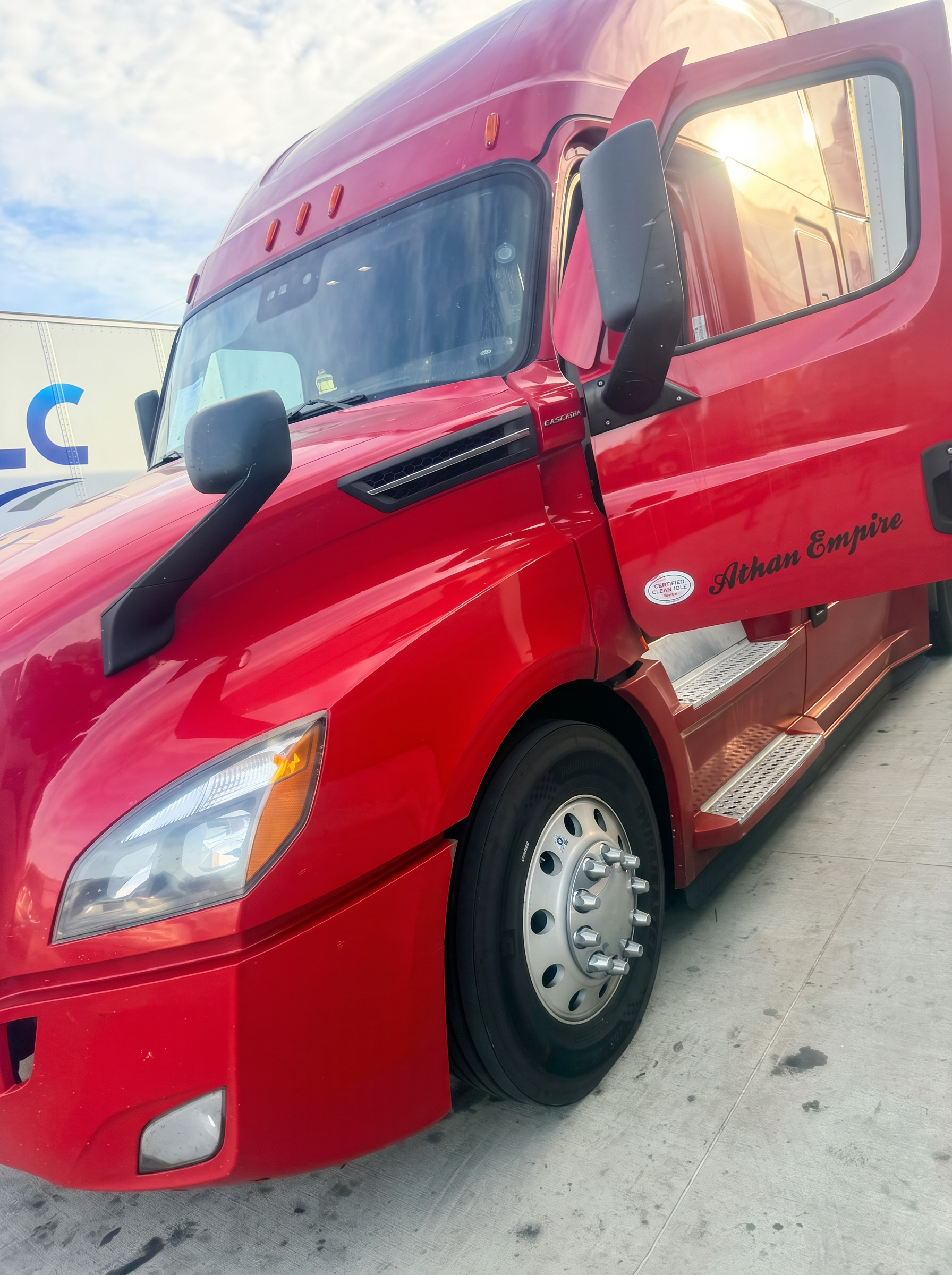 Red Freightliner Cascadia sleeper cab with driver door open
